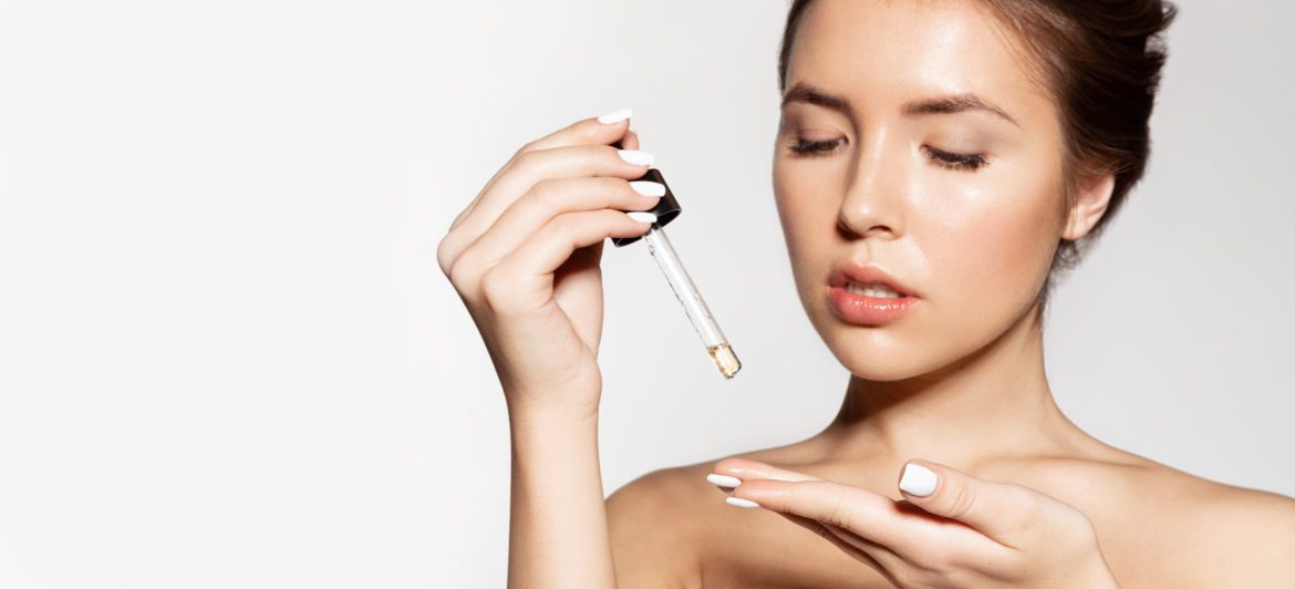 girl applying liquid oil for health skin essential oil skincare routine