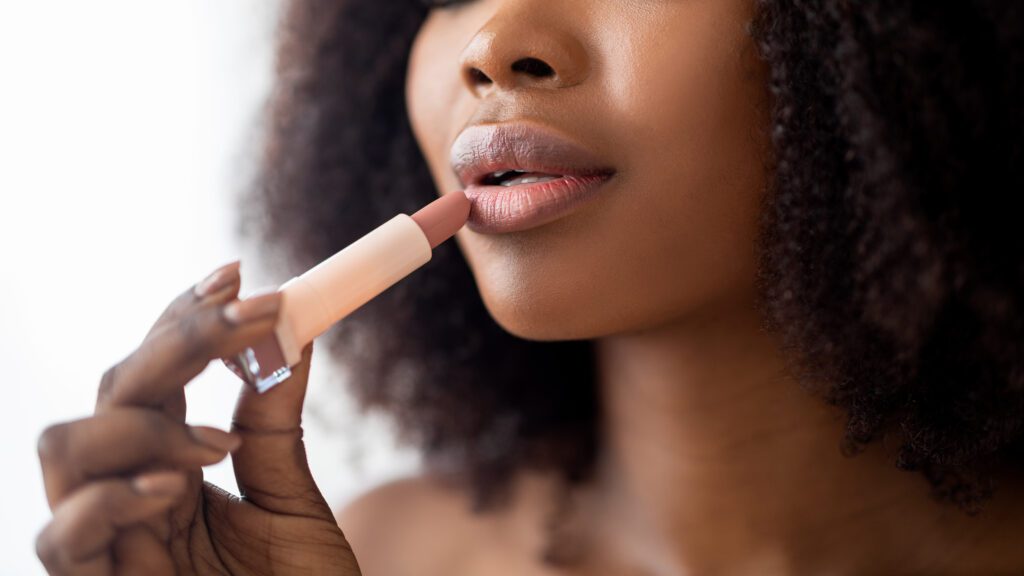 lady applying organic matte lipstick, closeup. Cropped view of millennial African American woman using decorative makeup, performing daily routine, banner design
