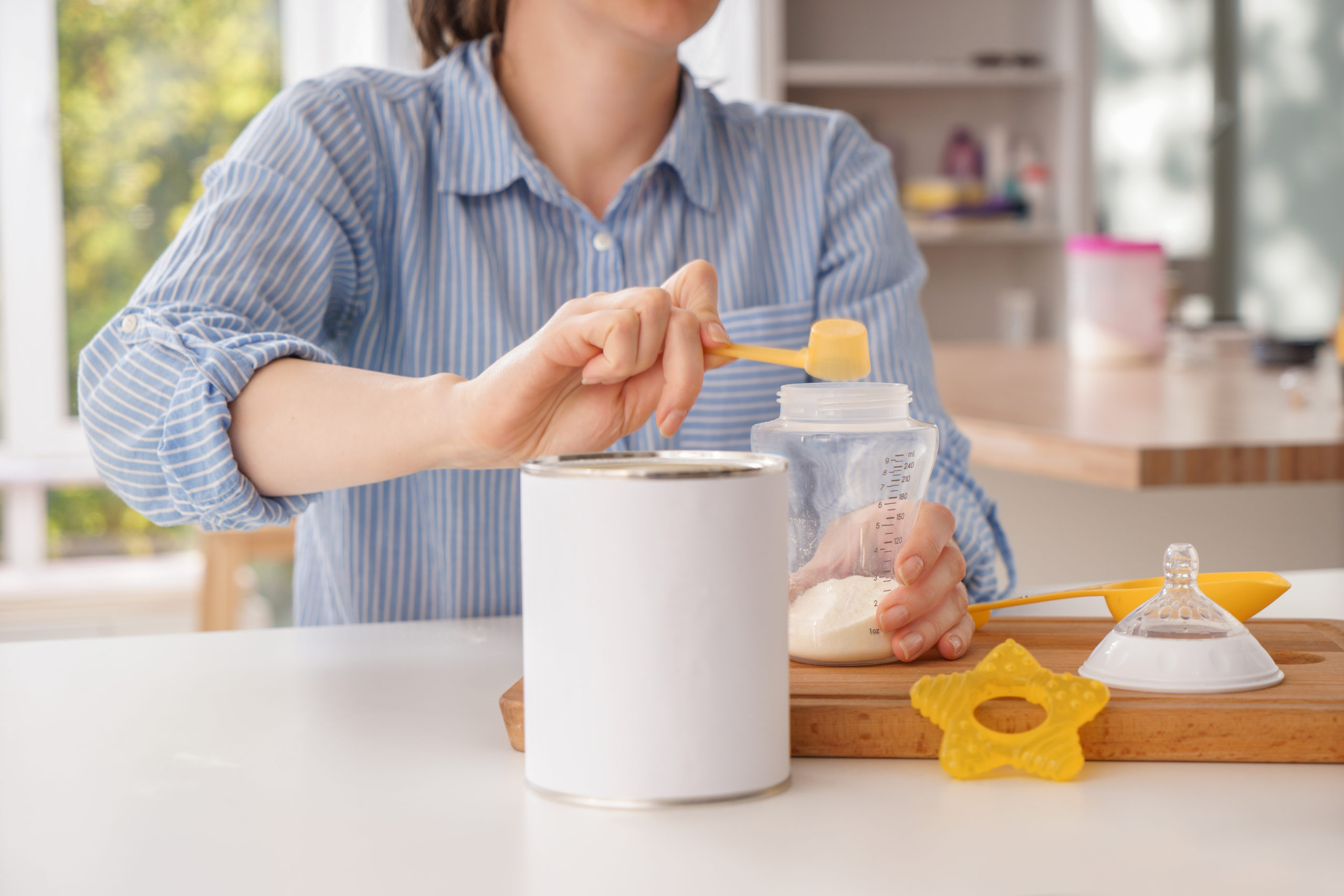 Woman,Preparing,Baby,Formula,At,Table