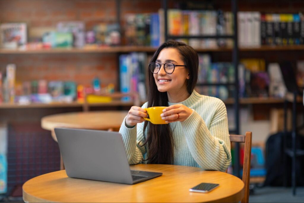 woman with black long hair drinking coffee in a cafe